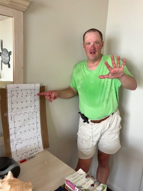 Aaron celebrates finishing 5 days of walking by marking the calendar and showing a high five.